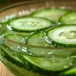Thinly sliced cucumbers soaking in salt water before making a salad.